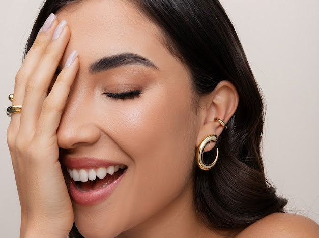 beautiful woman wearing gold earring and ring jewelry 